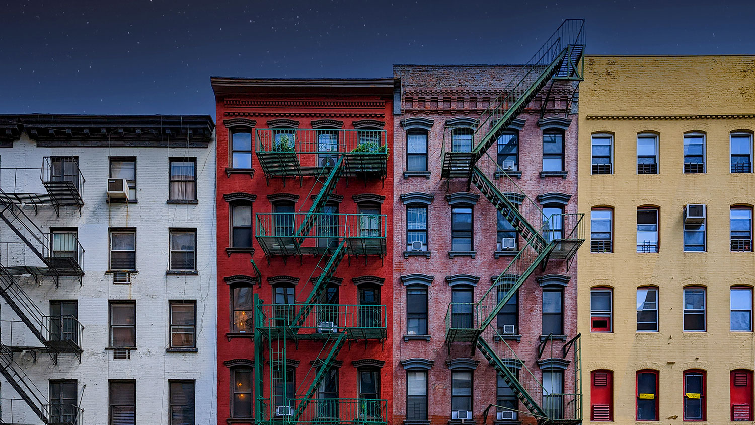 Row of New York City townhouses at night